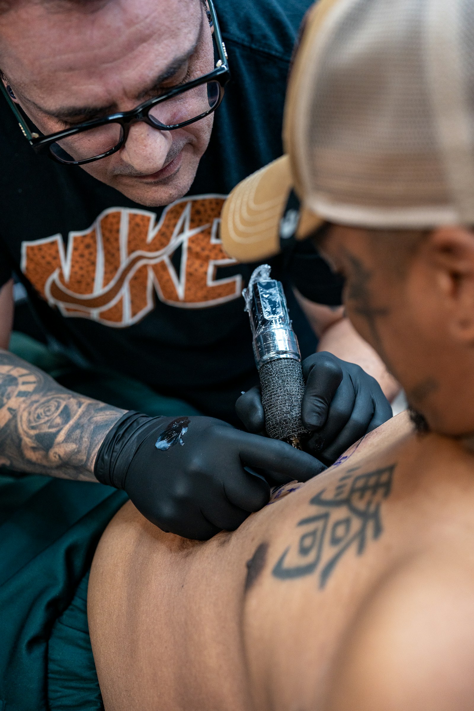 Tatuador trabajando en el brazo de un cliente durante una sesión